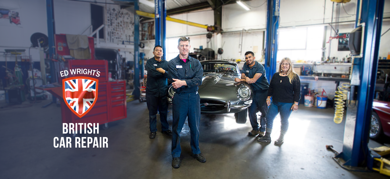 Staff and mechanics in the shop with a Jaguar 1969 XKE